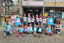 Flocke, Neben den Kindern sind darauf zu sehen (l.) Karen Biesgen vom städtischen Umwelt- und Grünflächenamt sowie (r.) OGS-Leiterin Monika Behlen.