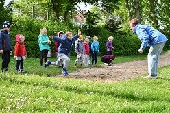 Kinder der Kita Hevener Straße beim Laufen, Werfen und Springen während der Veranstaltung.