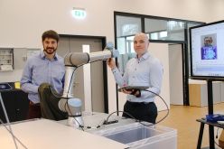 Eine Jacke mit Leuchtstreifen in den Händen: Prof. Dr.-Ing. Jens Schäfer (links) und Prof. Dr.-Ing. Steffen Greiser wollen smarte Textilien wie diese regional recyceln. Dafür setzen sie sowohl am Produktdesign als auch an der Sortierung durch Robotik/KI.