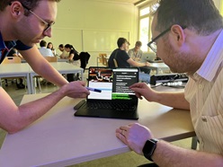 Werfen einen Blick auf den KI-Faktencheck-Prototyp: Dozent Rafael Bujotzek, rechts, mit Student Simon Kirschner Inzwischenzeit-Filme