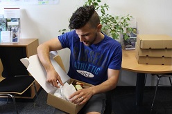 Ein Teilnehmer inspiziert bei der Abholung am Campus die „Taste the World -to go Box“, die alle Zutaten für die internationalen Rezepte enthielt.  THD