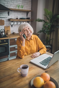 Ältere Frau am Telefon mit einem Laptop vor sich - so können Sie an der AMD-Aktionswoche teilnehmen: per Telefon oder online. / Bildrechte: iStock 