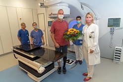 Dr. Christina Jentsch von der Klinik für Strahlentherapie und Radioonkologie (rechts) begrüßt den ersten mit dem neuen Linearbeschleuniger (LINAC) behandelten Patienten Jens Ulrich mit einem Blumenstrauß.  Marc Eisele  Universitätsklinikum Carl Gustav Carus Dresden