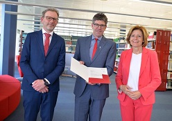 Ministerpräsidentin Malu Dreyer übergab in der Universitätsbibliothek den Förderbescheid an Michael Jäckel (Universitätspräsident) und Andreas Regelsberger (Dekan des Fachbereichs II).  Universität Trier
