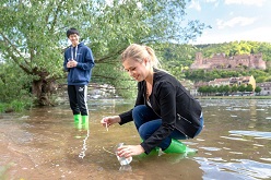 Das Bild zeigt Studierende der SRH Hochschule Heidelberg beim Entnehmen von Wasserproben aus dem Neckar.  SRH Hochschule Heidelberg