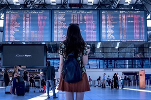 Dame studiert Infotafeln am Flughafen Foto Pixabay