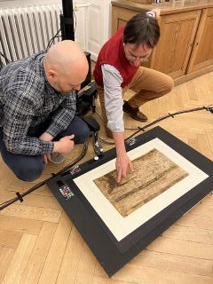 Prof. Dr. Michael Rathmann (KU Eichstätt-Ingolstadt) mit MSI-Spezialist Ivan Shevchuk (Universität Hamburg, links) betrachten Beschädigungen in einem Segment der Tabula Peutingeriana in der Österreichischen Nationalbibliothek Quelle: Philipp Köhner