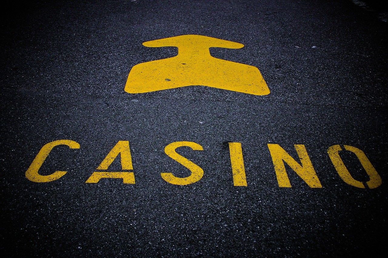  Auf einer Straße steht das Wort „Casino“ geschrieben. Darüber befindet sich ein Pfeil, der den Weg anzeigt. 
