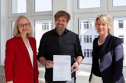 FHM-Rektorin Prof. Dr. Anne Dreier (rechts) und Medien-Dekanin Prof. Dr. Astrid Kruse (links) überreichten Stefan Finger die Urkunde zur Professur.  Fachhochschule des Mittelstands