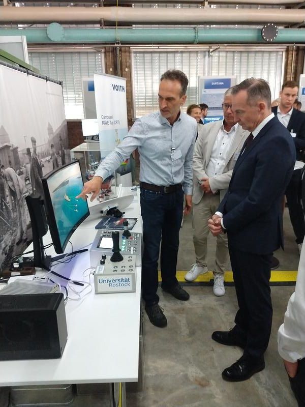 Dr.-Ing. B. Kolewe demonstriert dem Bundesminister f. Digitales u. Verkehr, Dr. V. Wissing, die Funktionalitäten einer mobilen Kommandozentrale für den kooperativen Betrieb autonomer, elektrisch angetriebener Schub- und Schleppermodule zur Schiffsassistenz  Prof. Dr. Torsten Jeinsch  Universität Rostock