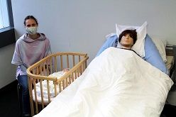 Auf eine solche Situation der Wochenbettbetreuung trafen die Studentinnen in der Prüfung: Yvonne Forster (im Bild links) sprach die Rolle der Mutter. Die Studentinnen arbeiteten mit den beiden Modellen (Mutter und Neugeborenes).  Judith Merkelt-Jedamzik  hsg Bochum/jmj