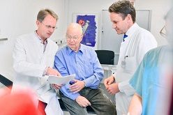 Die Projektleiter der DIGIT-HF-Studie Prof. Dr. Udo Bavendiek (ganz l.) und Prof. Dr. Johann Bauersachs (ganz r.) von der Klinik für Kardiologie und Angiologie der Medizinischen Hochschule Hannover (MHH) im Gespräch mit einem Patienten.  Foto: Tom Figiel/MHH  MHH