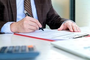 Geschäftsmann, der die Vereinbarung im Vertrag unterzeichnet Symbolbild